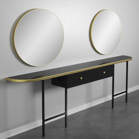 Moderner Konsolentisch mit zwei runden Wandspiegeln, schwarzes Holz mit goldenen Akzenten, vor grauer Wand.