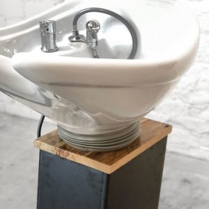 Moderner Friseursalon Waschbecken mit stilvollem Design auf hölzerner Basis, ideal für professionelle Haarpflege.