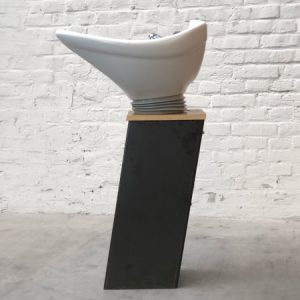 Modernes Haarsalon-Waschbecken auf Metallständer vor Backsteinwand im Industrie-Design.