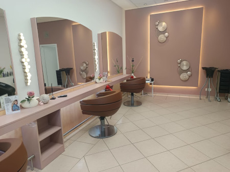 Moderner Friseursalon mit stilvollen Frisiertischen und eleganter Dekoration für ein entspanntes Erlebnis.